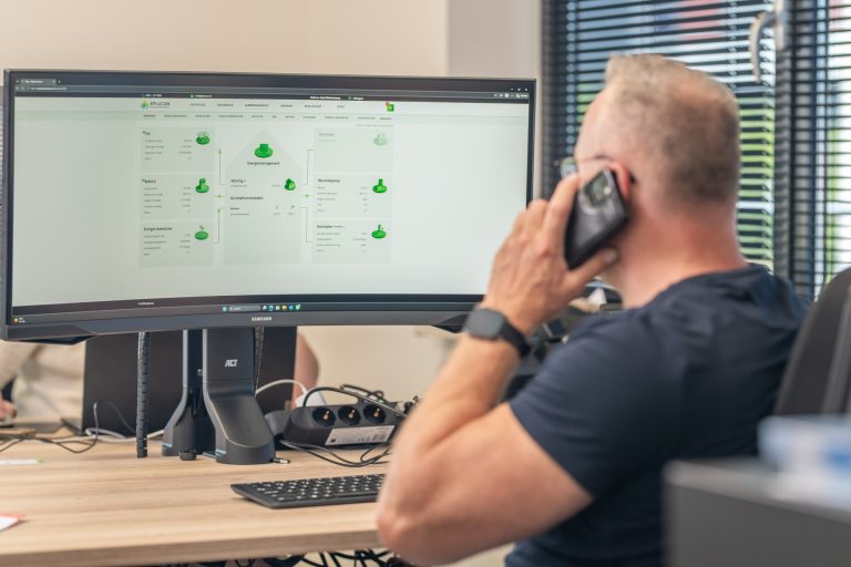 Medewerker aan de telefoon met het E-Control dashboard op het scherm