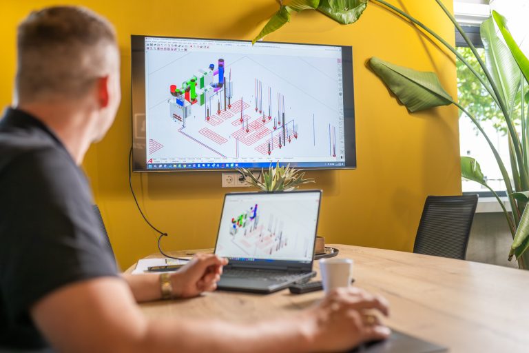 Medewerker werkt aan een 3D-installatietekening op een groot scherm